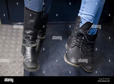 Women Sitting Together On Subway Train Close Up Of Boots Stock Photo