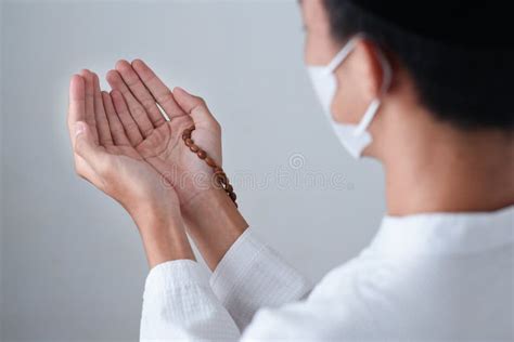 Close Up Hand Of Muslim Man With Prayer Beads Pray To God On Grey