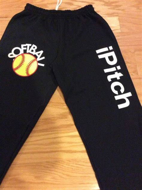 A Pair Of Black Sweatpants With Softball Logos On The Bottom And Words