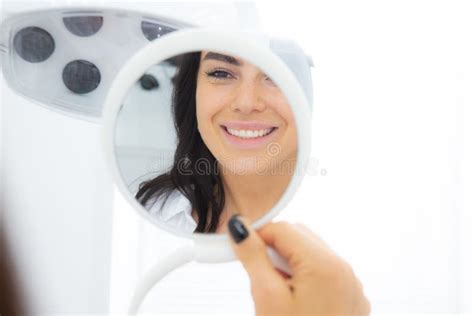 Beautiful Woman Looking In The Mirror At The Dentist Office Enjoying