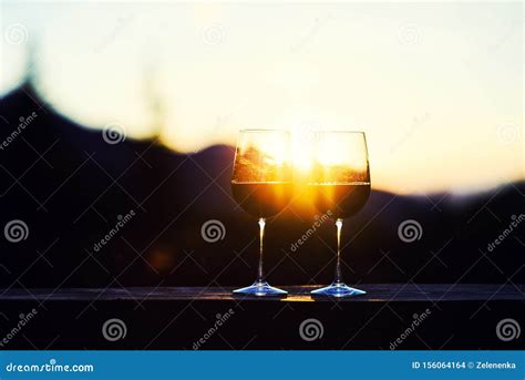 Two Glasses Of Wine At Sunset Dramatic Sky On Mountain Landscape