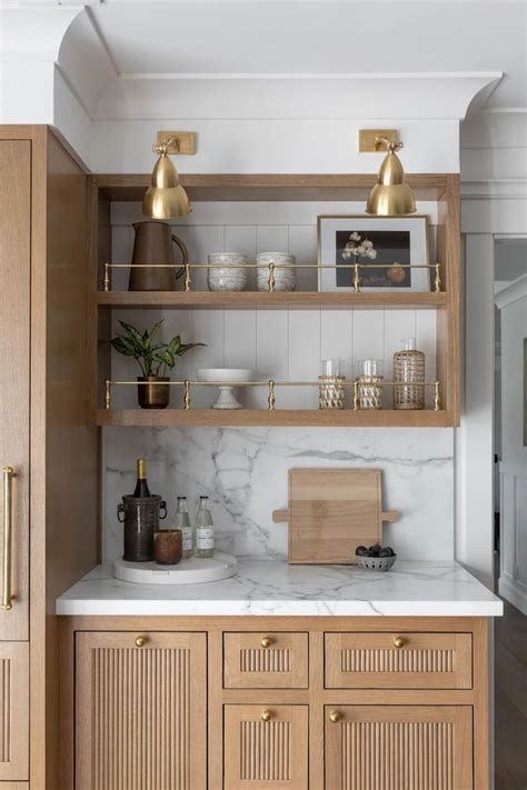 A Kitchen With Wooden Cabinets And Marble Counter Tops Gold Accents On