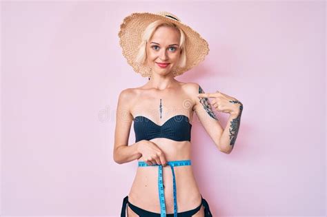 Jeune Femme Blonde Avec Tatouage En Bikini Avec Mesure Sur Bande Pointant Le Doigt Vers Un Soi