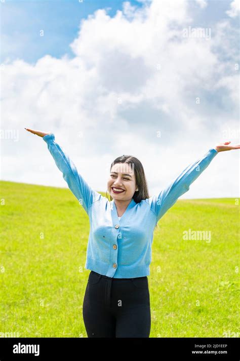 Smiling Young Woman Spreading Her Arms In The Field Concept Of Free