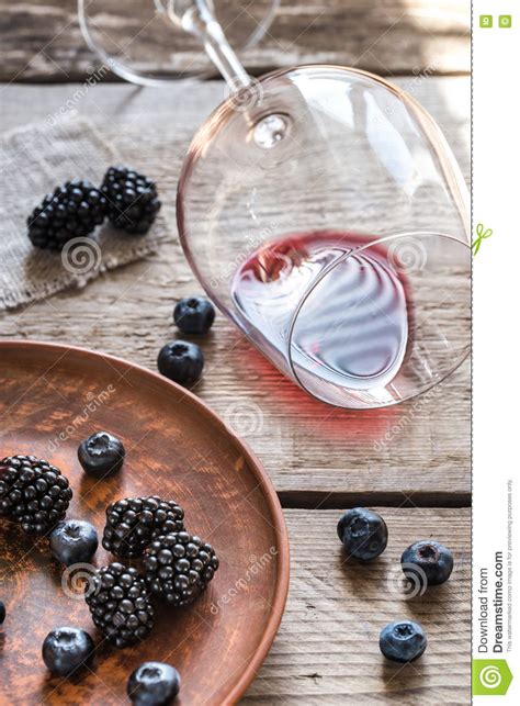 Glass Of Red Wine With Fresh Berries On The Wooden Table Stock Photo