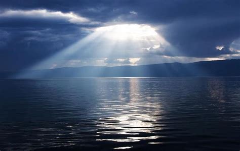 The Sun Shines Through Clouds Over Water