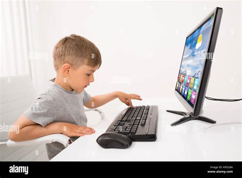 Niño escribiendo en el teclado fotografías e imágenes de alta