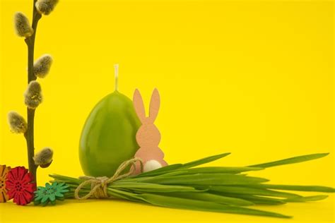 Premium Photo Easter Holiday Background With Egg Shaped Candle Pussy Willow Branch And Bundle