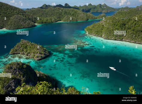 Aerial view of a boat making its way through the Wayag Islands, an ...