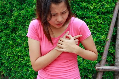 Sección media de una mujer con dolor en el pecho de pie al aire libre