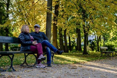 Um Casal Idoso Sentado No Banco Do Parque Foto Foto Premium