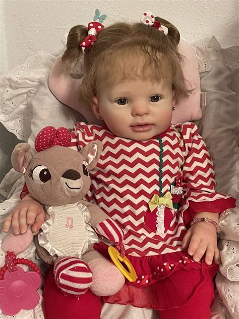 A Baby Doll Sitting Next To A Teddy Bear