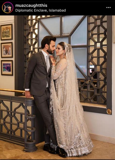 A Bride And Groom Standing Next To Each Other In Front Of A Window With