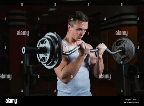 Closeup Portrait Of A Muscular Man Workout With Barbell At Gym