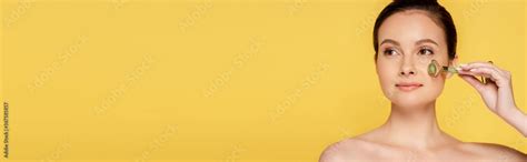 Beautiful Naked Woman Using Jade Roller On Face Isolated On Yellow Panoramic Shot Stock Photo