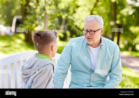 grandfather and grandson talking at summer park Stock Photo - Alamy