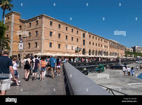 Tourists Walking Along The Promenade Passing The Catalunya Museum