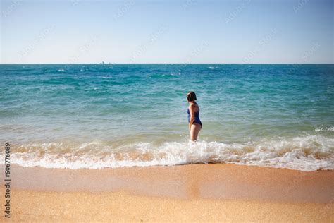 overweight teenager girl runs on beach to sea, child girl in one-piece ...