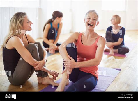 Cuatro mujeres sentadas en el suelo en clase de pilates Fotografía de