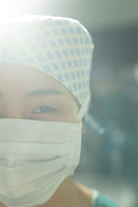 Vertical Of Smiling Asian Female Surgeon In Gown Mask Gloves And Cap