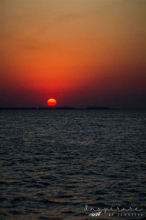 Mar Chiquita salt water lake at sunset with the red sun sinking below the horizon in Cordoba ...