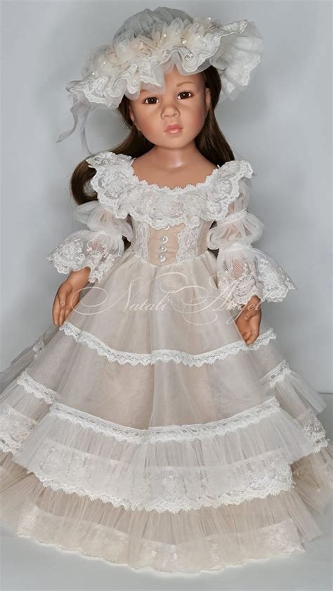 A Doll Wearing A White Dress And Bonnet