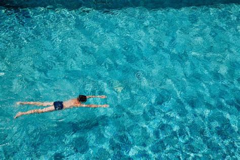 Muchacho Adolescente Que Nada Bajo El Agua En Una Piscina Al Aire Libre