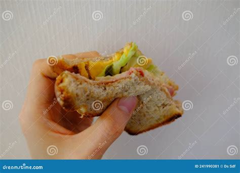 Bite Sandwich With Hand Holding Oat Bread Bacon Lettuce And Cheddar