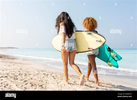 Mujeres surfistas tablas de surf caminando juntos playa fotografías e