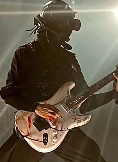 A Person With A Guitar In Their Hand And Wearing A Helmet On His Head