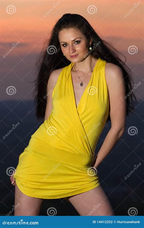 Jeune Femme Sexy De Brunette Dans La Robe Jaune Courte Photo Stock