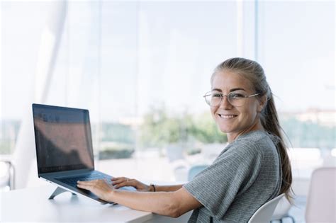 Premium Photo Blonde Girl With Glasses Turned To Face The Camera While Working In Front Of A