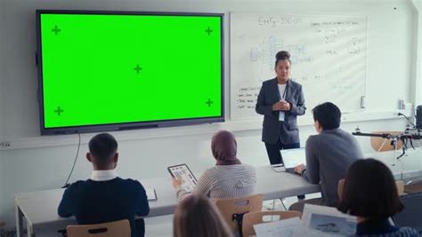 Black Female Teacher Explains Lesson To Students Uses Green Screen