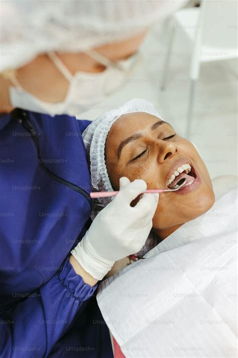 A Woman Getting Her Teeth Checked By A Dentist Photo Botox Image On Unsplash