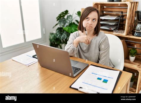 Brunette Woman With Down Syndrome Working And Thinking At Business