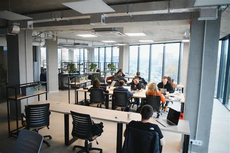 Premium Photo A Group Of People Sitting At Tables In A Large Open