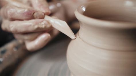 Man Potter Working On Potters Wheel Making Ceramic Pot From Clay In