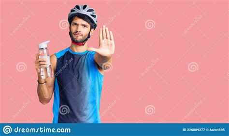 Handsome Hispanic Man Wearing Bike Helmet And Holding Water Bottle With