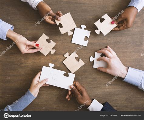 Group Of Business People Assembling Jigsaw Puzzle Together Stock