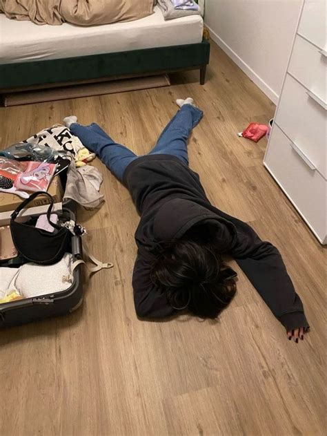 A Person Laying On The Floor With Their Head In An Open Suitcase And