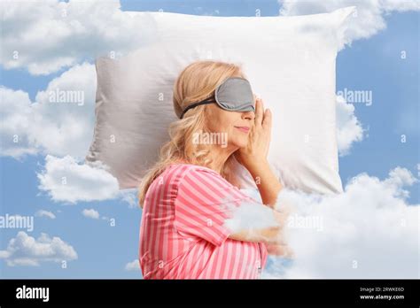 Mature Woman In Pajamas Sleeping With A Mask Over A Pillow With Clouds