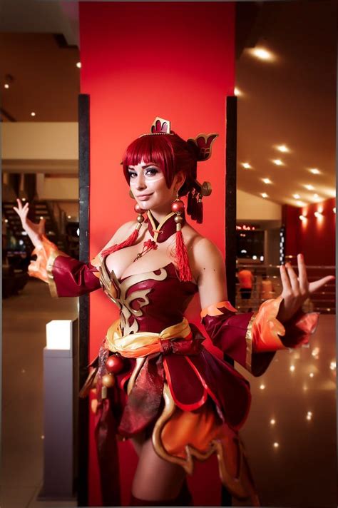 a woman dressed in costume standing next to a red wall