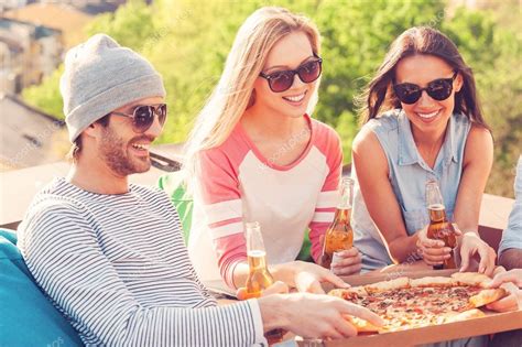 Personas Comiendo Pizza Y Bebiendo Cerveza Fotografía De Stock