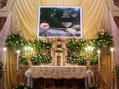 The Altar Is Decorated With Flowers Candles And An Image On The Wall