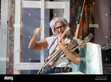 Older Gray Haired Mature Laughing Happy Artist Woman With Glasses And