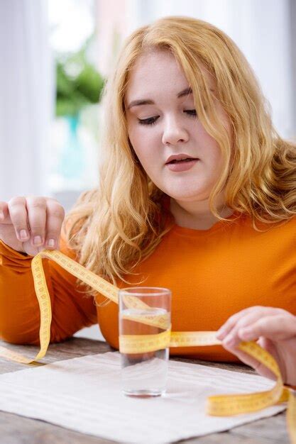 Determinación mujer con sobrepeso determinada sentada en su mesa y