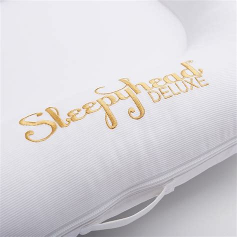 the sleepy head deluxe pillow has gold lettering on it's side and is white