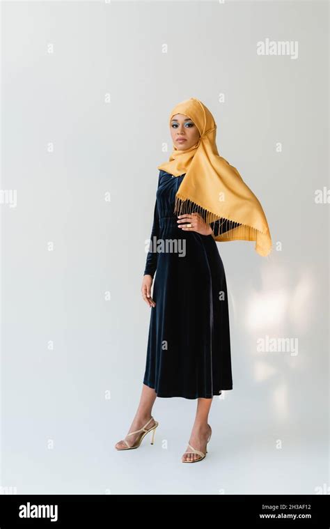 Full Length Of Dreamy Muslim Woman In Hijab And Velvet Blue Dress