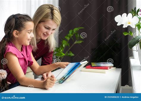 Belle Jeune Mère Aidant Sa Petite Fille à Faire Ses Devoirs Image stock