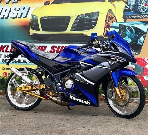 A Blue And Black Motorcycle Parked In Front Of A Car Wash Shop With